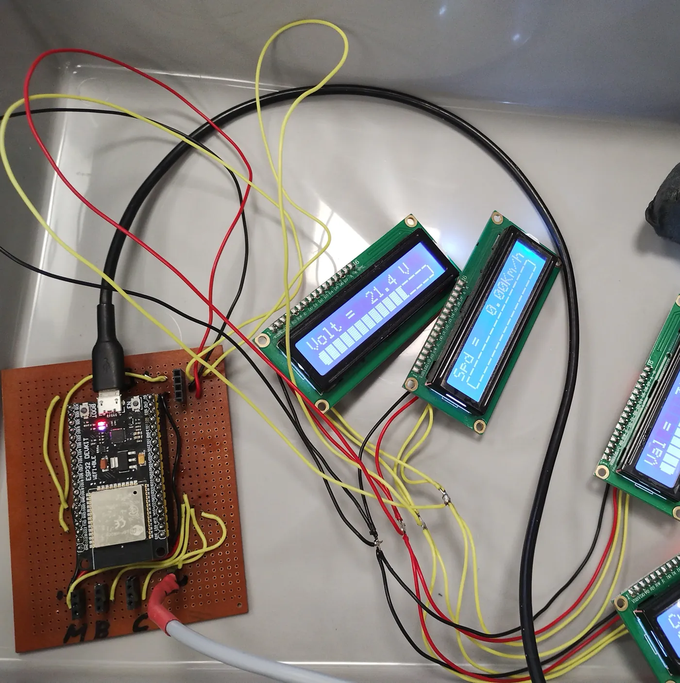 ESP32 wired to four small LCDs showing volts, speed, a sensor value and current