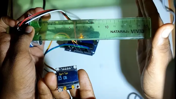 Digital measuring tape: ultrasonic sensor and display held against a ruler